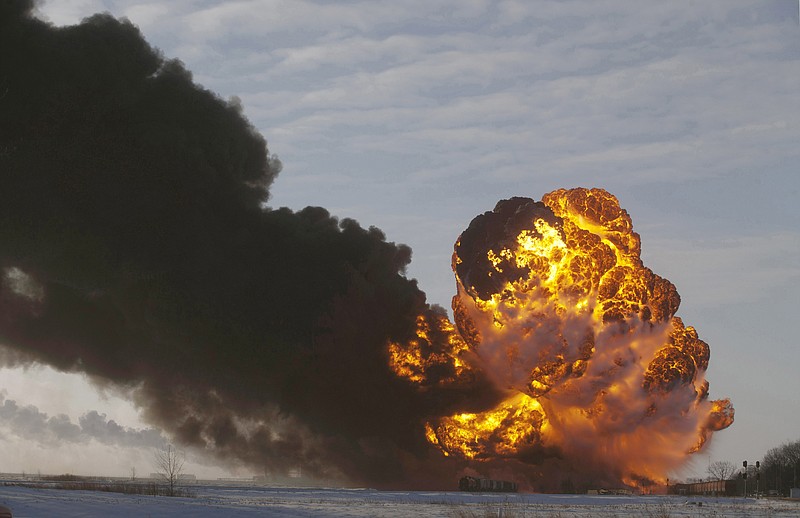 FILE - In this Dec. 30, 2013 file photo, a fireball goes up at the site of an oil train derailment near Casselton, N.D. The Trump administration is withdrawing a proposal for freight trains to have at least two crew members that was drafted in response to explosions of crude oil trains in the U.S. and Canada. Transportation officials said Thursday, May 23, 2019 that a review of accident data did not support the notion that having one crew member is less safe than a multi-person crew. (AP Photo/Bruce Crummy, File)