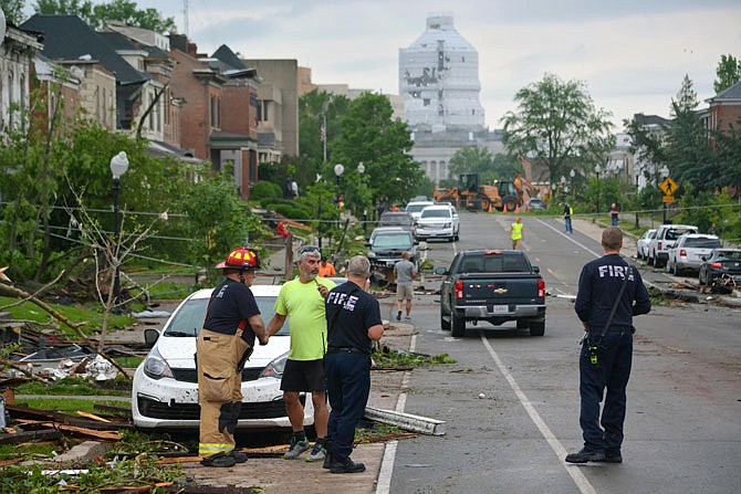 Residents observe damaged cars and homes Thursday after a tornado caused severe damage along both sides of Capitol Avenue. The National Weather Service ruled Wednesday's tornado as an EF-3 with peak winds reaching 160 mph.