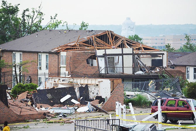 Contractors work to cover a side of the Firley YMCA on Ellis Boulevard on Thursday after the wall collapsed during a violent tornado that struck the city at 11:43 p.m. Wednesday.