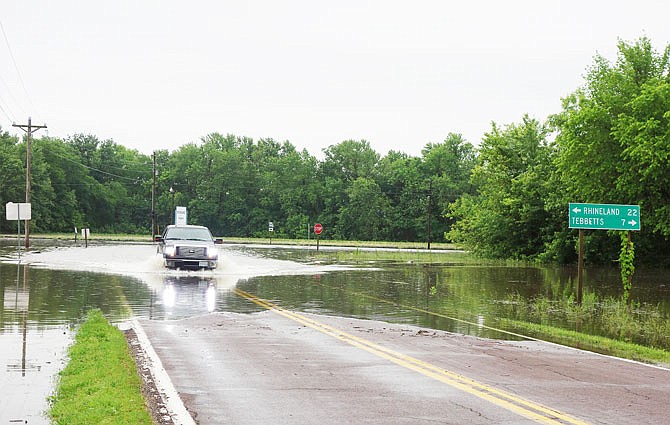 Ethan Livengood drives cautiously through the Missouri 94/Route C intersection in Mokane. He said the water in the intersection is just standing so far, rather than flowing. "I just came down to look at the water," he added.
