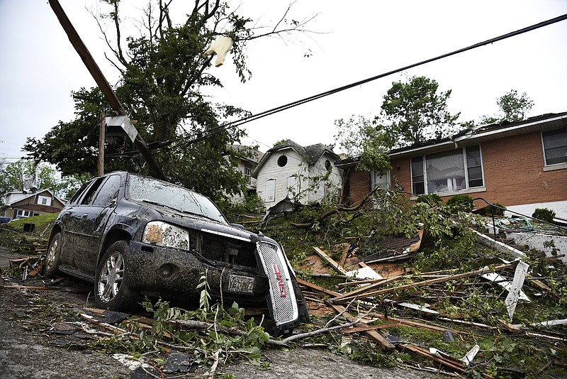 A damaged car sits covered in debris in front of a home on Thursday, May 23, 2019, following a tornado that cut through Jefferson City. 