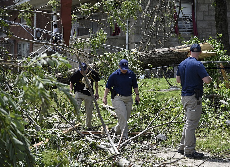 FBI agents navigate their way through debris on Thursday, May 23, 2019, along Jackson Street. Missouri Task Force One and FEMA were dispatched to Jefferson City after a tornado touched down, causing extensive damage throughout. 