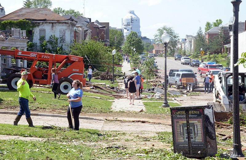 Mark Wilson/News Tribune
Workers and residents clean up debris along Capitol following the Wednesday nght storm that rolled through town.
