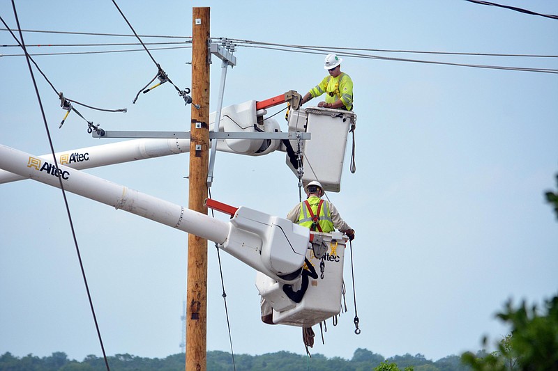 Utility workers install a new electric pole Friday, May 24, 2019, following a tornado that caused damage along Capitol Avenue and other parts of central Jefferson City.
