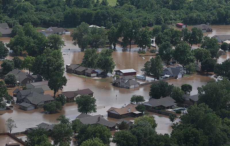 In this aerial image, homes are inundated with flood waters from the Arkansas River near South 145th West Ave near Highway 51 on Thursday, May 23, 2019, in Sand Springs, Okla. Storms and torrential rains have ravaged the Midwest, from Texas through Oklahoma, Kansas, Nebraska, Iowa, Missouri and Illinois, in the past few days. (Tom Gilbert/Tulsa World via AP)