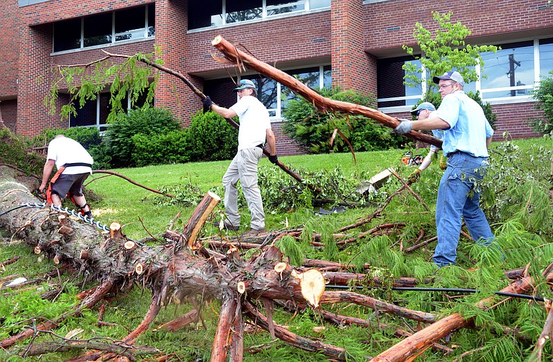 Mark Wilson/News Tribune
Facilities Management Design and Construction grounds crew members clean up tornado debris at the Missouri Division of Employment Security Saturday.