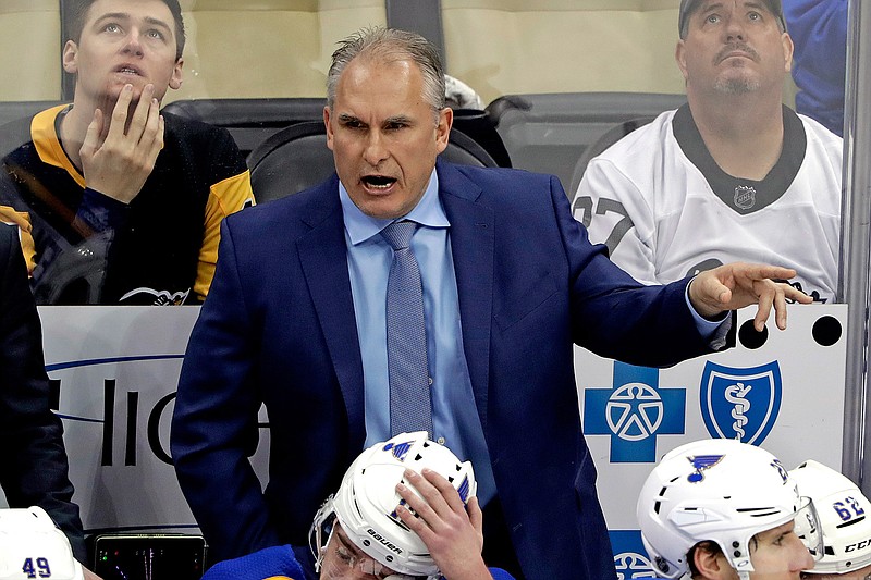  In this March 16, 2019, file photo, St. Louis Blues interim head coach Craig Berube gives instructions from behind his bench during the first period of an NHL hockey game against the Pittsburgh Penguins in Pittsburgh. Two roads diverged in a crazy world of hockey and brought them to this Stanley Cup Final. Cassidy has guided the Boston Bruins to this point a decade and a half after a disastrous tenure in Washington, and Berube took the St. Louis Blues from worst to their first final since 1970 several years after a short stint in Philadelphia. (AP Photo/Gene J. Puskar, File)