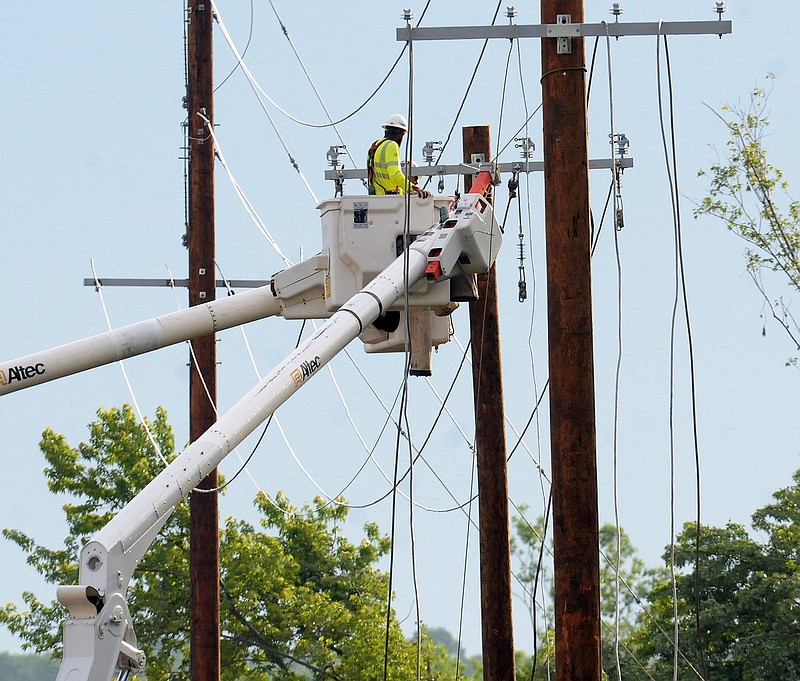 A utility crew from J.F. Electric repairs damage done Saturday by a tornado behind the Missouri State Penitentiary.