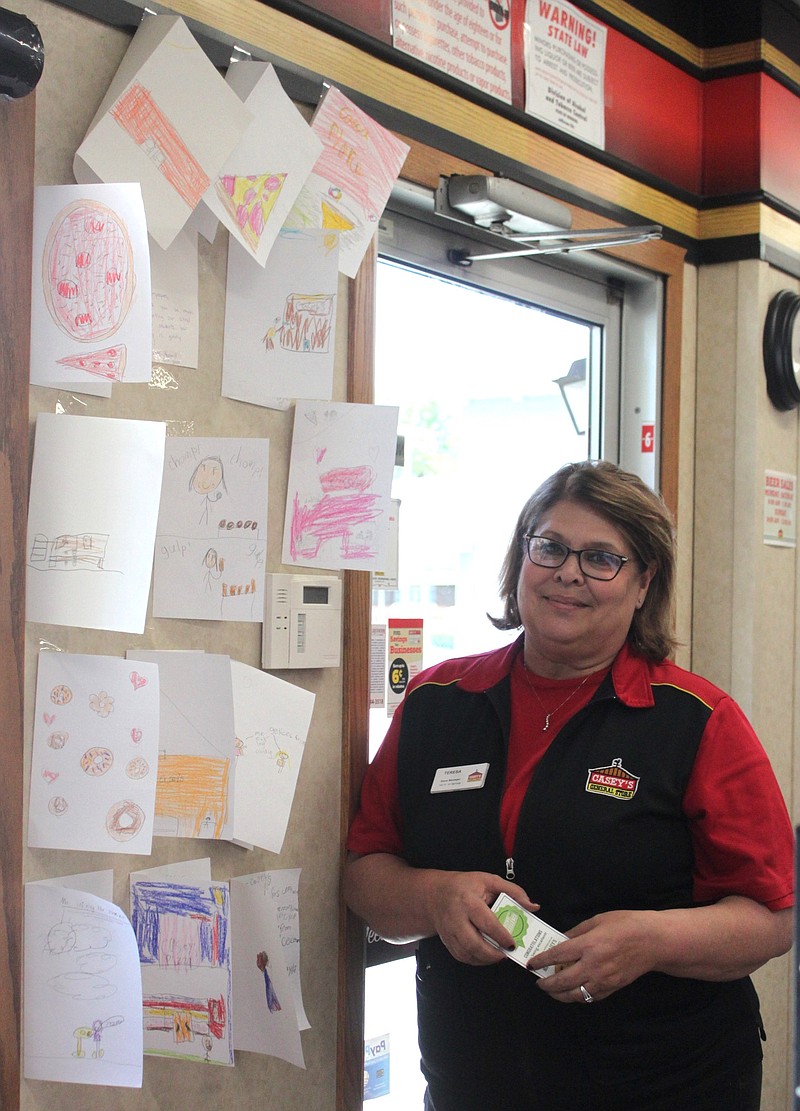 <p>Democrat photo/Liz Morales</p><p>Casey’s General Store manager Teresa Rich stands by her newly placed thank-you cards from Amy Howard’s CES second-grade class. The cards were in gratitude for Casey’s coupons the students received for achieving academic goals in reading, math and spelling.</p>