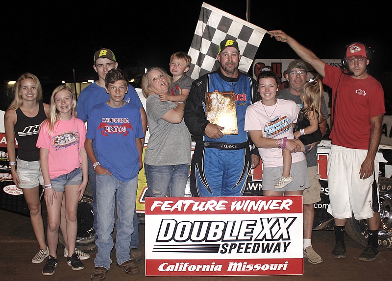 <p>Courtesy of Carol Wirts</p><p>California’s John Clancy Jr. made it to victory lane in the super stock feature just in time to claim the custom made Hockett Memorial Plaque. Clancy is pictured with his wife and grandson as well as crew members. The Hockett girls and Jesse’s father, Jack, presented the trophy aided by Double X Director A.J. Wirts.</p>