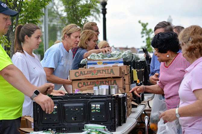 Volunteers with The Food Bank for Central & Northeast Missouri hand out food Tuesday to those in need outside of First Christian Church. The food bank prepared 9,500 pounds of fresh fruit, vegetables and nonparishable foods for families so they didn't need to worry about cooking.