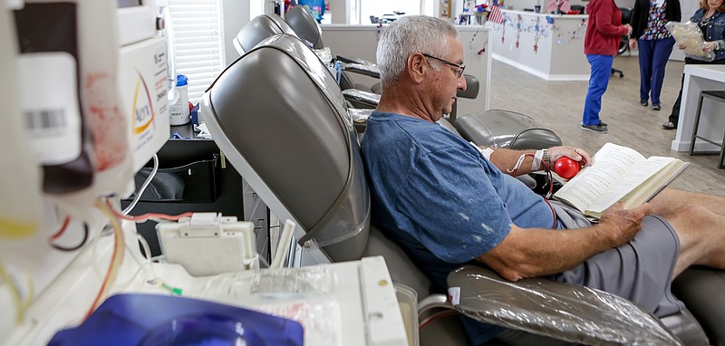 Ray Angle reads a book while donating blood Tuesday at LifeShare Blood Center in Texarkana, Texas. The center, at 4020 Summerhill Road, is unable to fill hospital orders and is rationing blood, officials said. 
