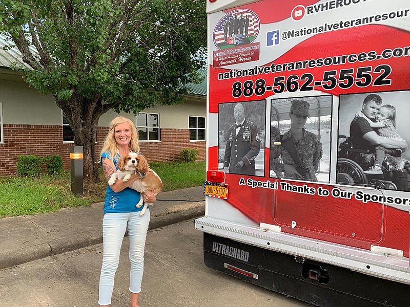 Michele Ladd and her dog, Chellis, pose Tuesday in front of Ladd's 32-foot RV. Ladd is traveling the country to promote awareness of veterans with post-traumatic stress disorder or suicidal thoughts.