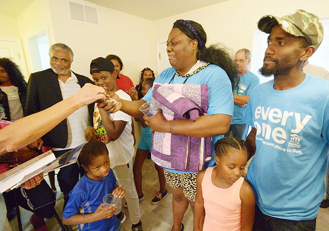 Bessie Muse and Henry Shelton receive keys to their new Habitat Home from Christa Johnston on Wednesday during a Habitat Home dedication ceremony at 807 Montana St.