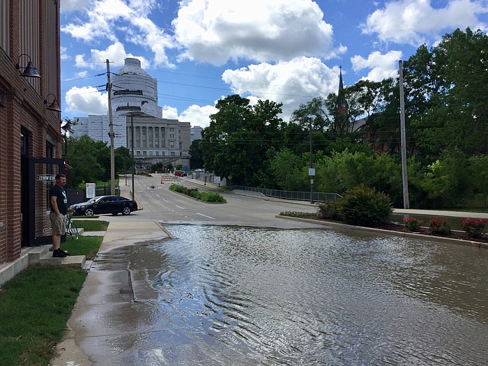 Nick Smith, owner of Red Wheel Bike Shop, surveys the rising water as he stands on the steps of his West Main Street business Thursday, May 30, 2019.  He said his shop should stay dry until water reaches the 34-foot mark. 