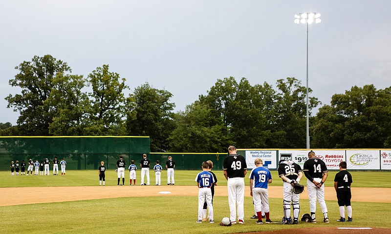 The Texarkana Twins, Texarkana, Texas, Dixie Youth 12 Rangers  and TY Yankees Youth 10 Texarkana Travel team bow their heads for a prayer before the game against the Baton Rouge Rougarous.