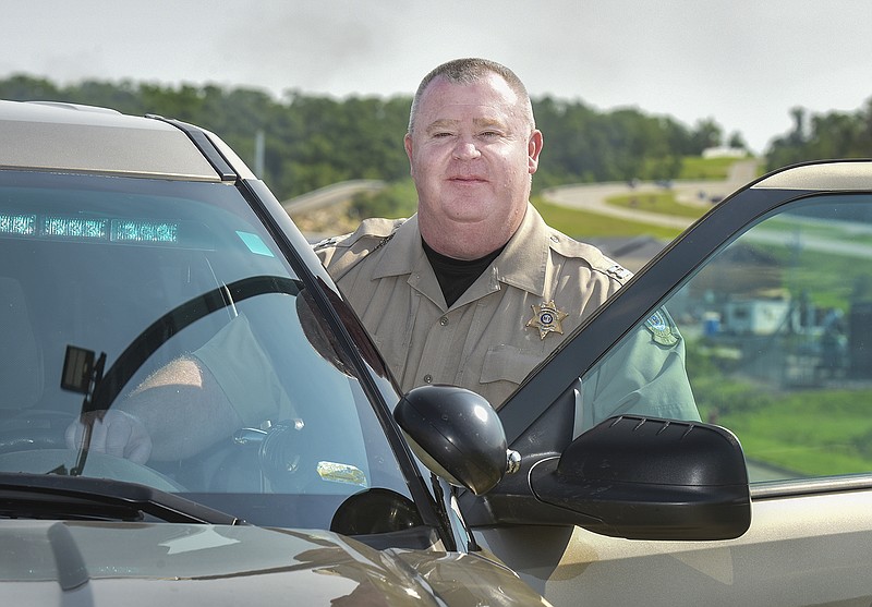 Cole County Sheriff's Capt. Kevin Woodson poses for a photo Friday beside a Sheriff's vehicle.