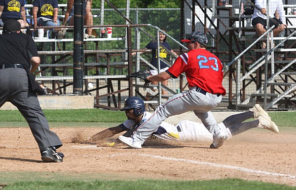 Dede Cole of the Renegades slides safely into home plate ahead of the throw to Clarinda pitcher Casey Candiotti on a wild pitch during the second inning of Sunday afternoon's MINK League game at Vivion Field.