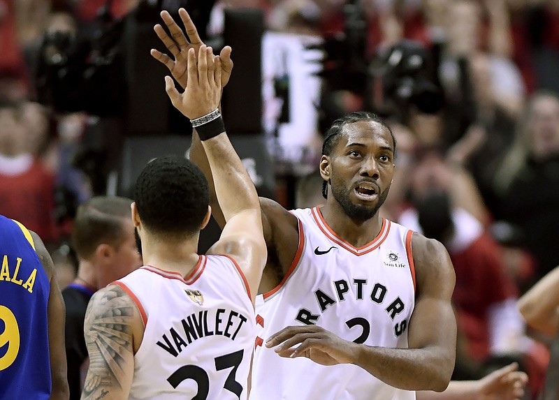 Toronto Raptors forward Kawhi Leonard (2) and teammate Fred VanVleet (23) celebrate a point against the Golden State Warriors during the first half of Game 2 of basketball's NBA Finals, Sunday, June 2, 2019, in Toronto. (Frank Gunn/The Canadian Press via AP)