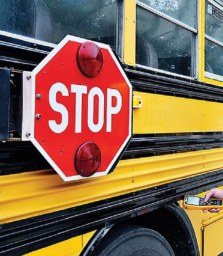 A First Student school bus is inspected with a hand-held electronic inspection device in this August 2012 photo.