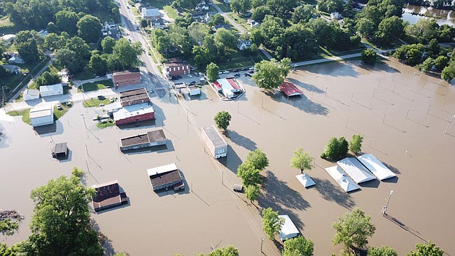 An aerial shot of downtown Mokane, taken by a Callaway County Sheriff's Office drone, shows extensive flooding affecting several buildings. Drivers are urged not to risk driving through standing water.