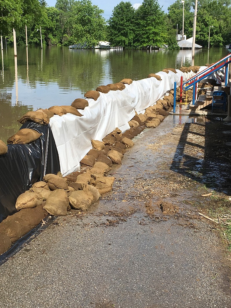 <p>A concrete wall beneath the plastic sheets and sandbags works Thursday with pumps to hold back the Missouri River from American Veterans Post #153 Mokane. Photo by Phillip Sitter</p>