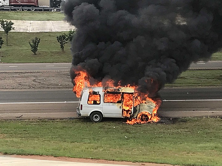 Maria Lopez and her son Joshua Ramos of Hope, Ark., watch their 2001 Astro van burn to ground Thursday, June 6, 2019,  on the side of the westbound lane on Interstate 30 near the State Line Avenue exit in Texarkana. Police officials say the vehicle started running poorly and Lopez saw smoke coming from the engine compartment. She pulled over, and the vehicle was on fire. She and her son escaped with no injuries. Photo by Tom Morrissey
