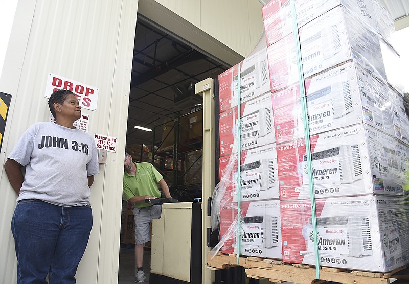 Anquenette McDonald watches as a pallet of donated window unit air conditioners is lowered by Shane Boessen, second from left, and a heavy duty hand truck at The Samaritan Center Friday, June 7, 2019. Ameren Electric donated 50 to the local pantry as they have done for several years now. McDonald, whose home was damaged by the tornado, is currently unable to use her central air conditioning and spoke up to get one to help her granddaughter, who suffers from asthma, be able to breathe easier and sleep better. 