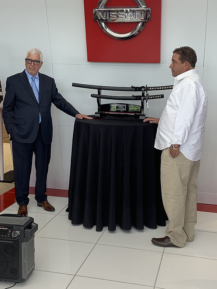 Pete Mankins, left, and Brant Smith, right, received Samurai swords from the Nissan corporate office Friday during their grand reopening celebration of the Smith Mankins Nissan dealership, located at 3707 Summerhill Road. The remodel has made the dealership high-tech and is complete with touch-screen tablets for shoppers to customize their driving experience. Staff photo by Jennifer Middleton