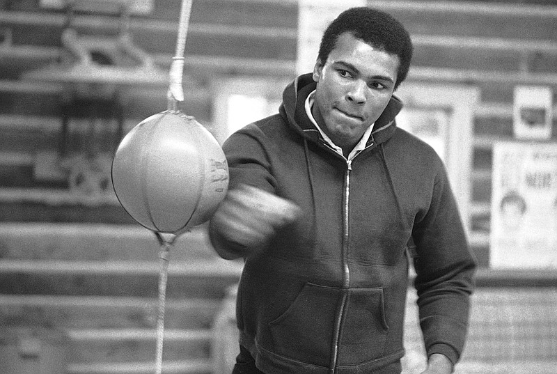 FILE -- In this Jan. 10, 1974 file photo, Muhammad Ali punches a bag in his Deer Lake, Pa., training camp where he was preparing for his rematch with Joe Frazier. The rustic Pennsylvania training camp where Ali prepared for some of his most famous fights has undergone an elaborate restoration. The camp in Deer Lake opened to the public Saturday, June 1, 2019 as a shrine to his life and career. (AP Photo/ Rusty Kennedy)