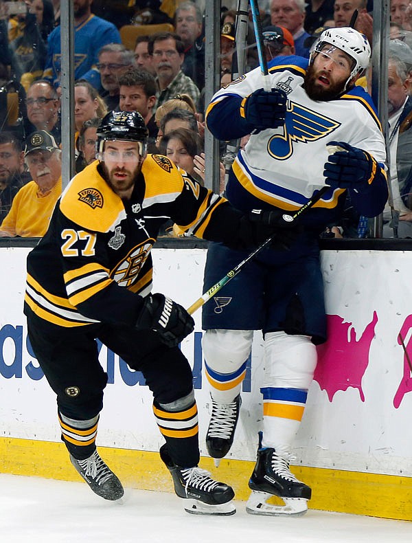 John Moore of the Bruins checks Patrick Maroon of the Blues into the glass during the first period in Game 5 of the Stanley Cup Final on Thursday in Boston. 