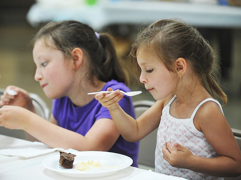 In this June 15, 2016, file photo, Stella Hirschvogel, 4, near, and Hazel Werner, 8, enjoy a sweet treat at St. Mary's Auxiliary Ice Cream Social at St. Joseph Cathedral Undercroft in Jefferson City.