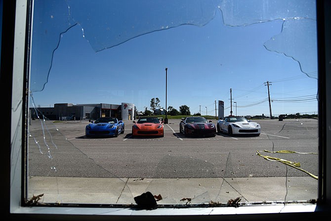 Corvettes are seen through a shattered window Monday on the Riley Chevrolet lot. The dealership faced extensive damage following the tornado that tore through Jefferson City on May 22.