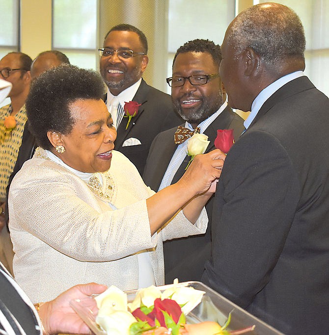 Gwen Edmonson pins roses onto fathers during the annual Juneteenth Fathers' Day Awards Banquet on June 8, 2019, at Lincoln University's Scruggs Center.