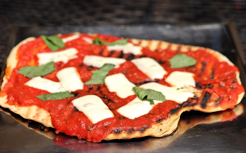 Make your own pizza on the barbecue grill, shown here with basil and mozzarella. (Hillary Levin/St. Louis Post-Dispatch/TNS) 