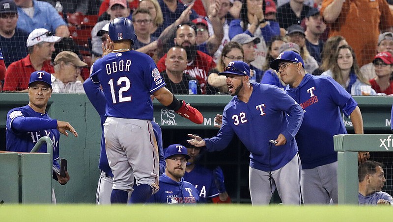 Texas Rangers' Rougned Odor (12) is congratulated after scoring on a single by Danny Santana during the sixth inning of a baseball game against the Boston Red Sox at Fenway Park in Boston, Monday, June 10, 2019.