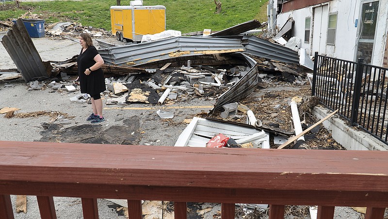
Avenue HQ owner Holly Stitt is seen in the background, standing amongst the debris, while being interviewed Wednesday, June 19, 2019, so she can tell the story of the damage her company's properties suffered during the May 22, 2019 tornado in Jefferson City. 