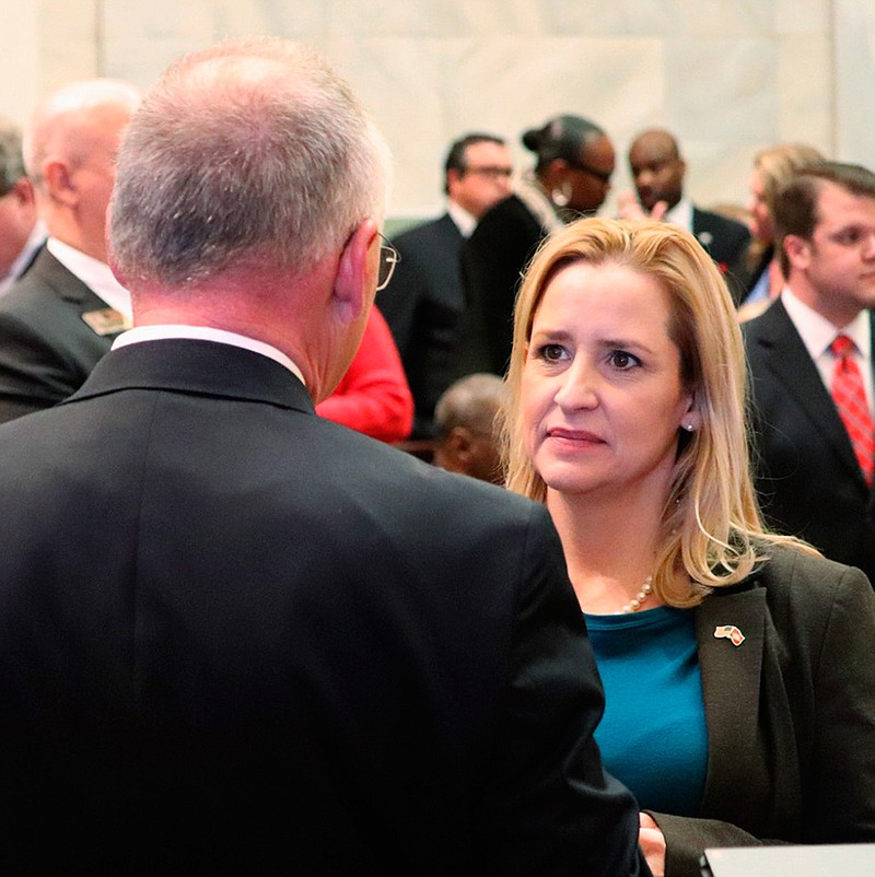 In this Feb. 12, 2018, file photo, Arkansas Attorney General Leslie Rutledge, right, speaks with Parliamentarian Buddy Johnson in the Arkansas House chamber in Little Rock. A federal lawsuit alleges the voting system for some Arkansas judges violates black residents' rights by diluting the strength of the vote. Lawyers for the NAACP Legal Defense Fund filed the lawsuit Monday, June 10, 2019. A spokeswoman says state Attorney General Leslie Rutledge is reviewing the complaint. (AP Photo/Kelly P. Kissel File)