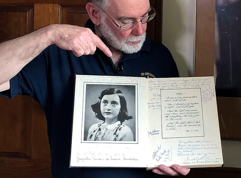 In this June 7, 2019 photo, Ryan Cooper holds a 1972 portion of a diary that he wrote when he visited Otto Frank, the father of the famed Holocaust victim and diarist Anne Frank, at his home in Yarmouth, Mass. The diary includes a photo of Anne Frank and the autographs of other people he met who knew her. Cooper has donated a trove of letters and mementos he received from Otto Frank to the U.S. Holocaust Memorial Museum ahead of the 90th anniversary of Anne Frank's birthday. (AP Photo/Philip Marcelo)