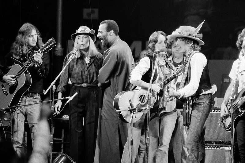 FILE - In this Dec.1975 file photo,  musicians Roger McGuinn, Joni Mitchell, Richi Havens, Joan Baez and Bob Dylan perform the finale of the The Rolling Thunder Revue, a tour headed by Dylan. Martin Scorsese’s latest film, “Rolling Thunder Revue: A Bob Dylan Story By Martin Scorsese,” is a blistering semi-fictional documentary that resurrects Dylan’s mythic 1975-1976 tour and its rambling cavalcade across a post-Vietnam America. The film, which opens Wednesday in limited theaters and on Netflix, includes restored performance footage, scenes of the backstage circus and interviews with many of the participants, including Dylan’s first on-camera interview in 10 years. (AP Photo, File)