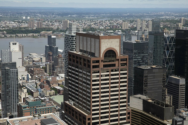 Law enforcement personnel work on the roof of the AXA Equitable building, center, Tuesday, June 11, 2019 in New York. A helicopter crashed Monday on the roof of the rain-shrouded Manhattan skyscraper, killing the pilot, Tim McCormack, of Clinton Corners, N.Y. (AP Photo/Mark Lennihan)