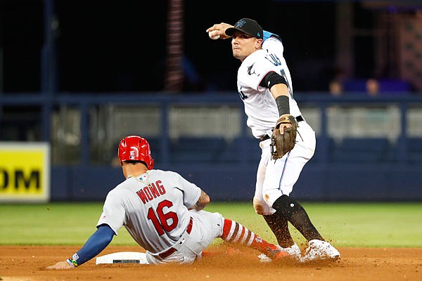 Marlins shortstop Miguel Rojas throws to first after forcing out Kolten Wong of the Cardinals at second base during the fifth inning of Wednesday's game in Miami.