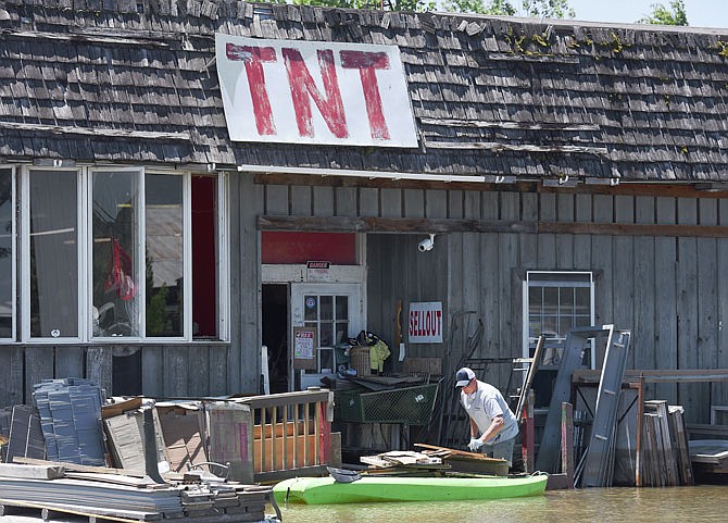 Todd Tibbetts, owner of TNT Surplus in North Jefferson City, uses a kayak to get around the lot and to take items to the back of the building to a large dumpster. In 1993, these series of buildings housed Great Central Lumber, which ended up moving out of the flood zone and to higher ground. 