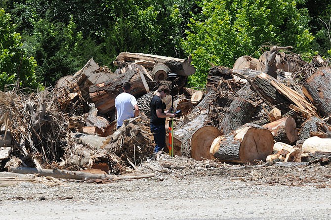 Workers measure the volume of storm debris Thursday at a Jefferson City Storm Debris Disposal Site at Capital Quarries Company, 2619 N. Shamrock Road.
