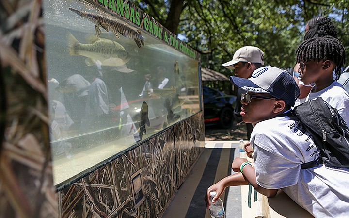  Children from the community look at the aquarium filled with different species of fish and turtles from the Arkansas Game and Fish Commission on Thursday at Camp Preston Hunt in Texarkana, Ark. Miller County Conservation District hosted a nature education day for hands-on learning experiences for children between the ages of 9 to 16. Staff photo by Hunt Mercier