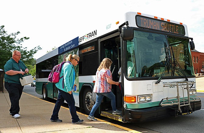 Employees of the Harry S Truman Building load onto a JeffTran bus Friday to be shuttled back to their vehicles after work. The state Office of Administration announced Friday the bus shuttle system would be ending because of receding floodwaters.