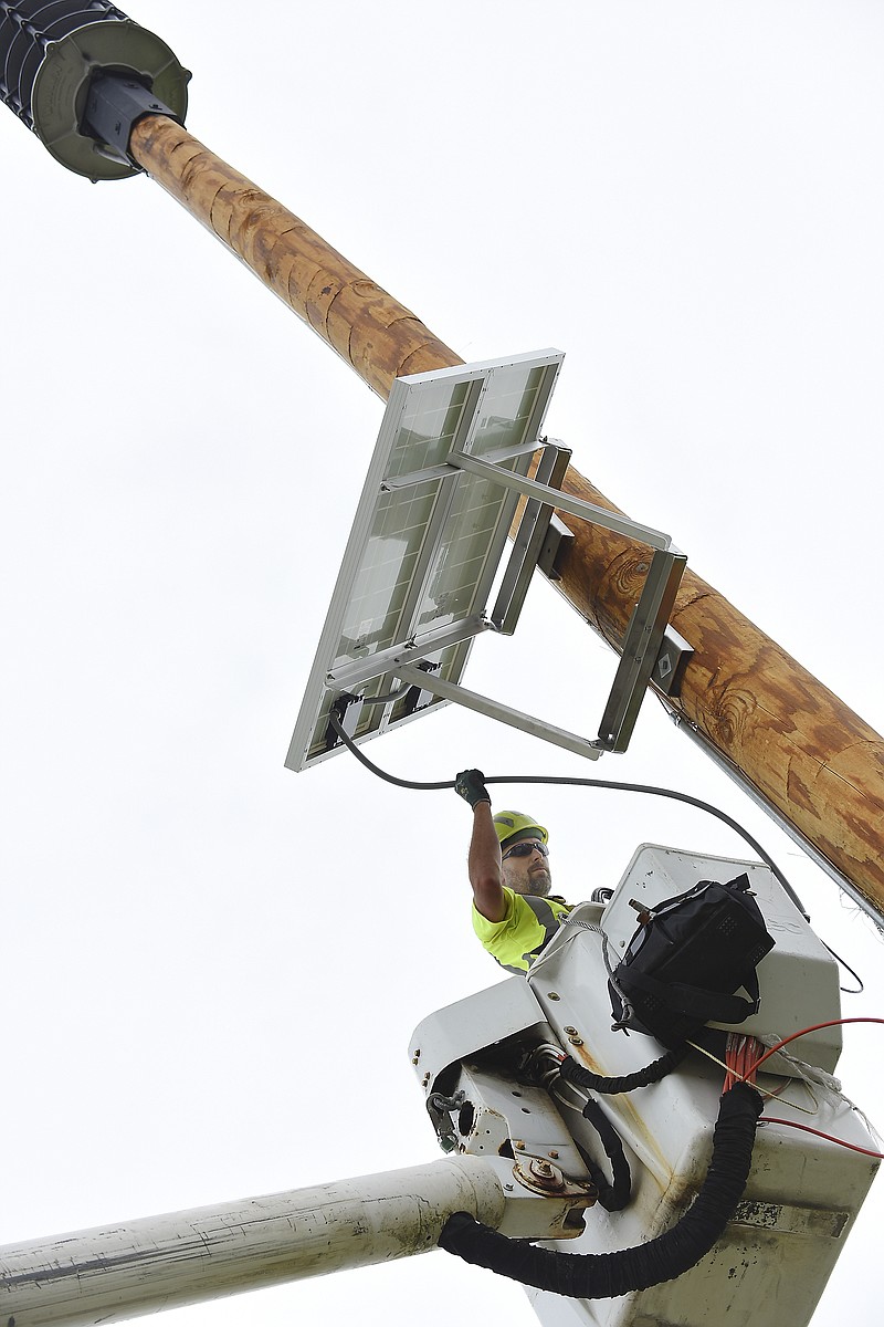 
Randy Vandelicht, a signal technician for Meyer Electric, attaches a solar panel to a just-installed 60-foot pole that now holds the speaker system and power supply for the outdoor warning siren. Vandelicht is part of the crew who set the pole and provided installation for the equipment. 