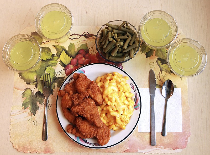 This undated photo provided by the National Institutes of Health in June 2019 shows an "ultra-processed" lunch including brand name macaroni and cheese, chicken tenders, canned green beans and diet lemonade. Researchers found people ate an average of 500 extra calories a day when fed mostly processed foods, compared with when the same people were fed minimally processed foods. That’s even though researchers tried to match the meals for nutrients like fat, fiber and sugar. (Paule Joseph, Shavonne Pocock/NIH via AP)