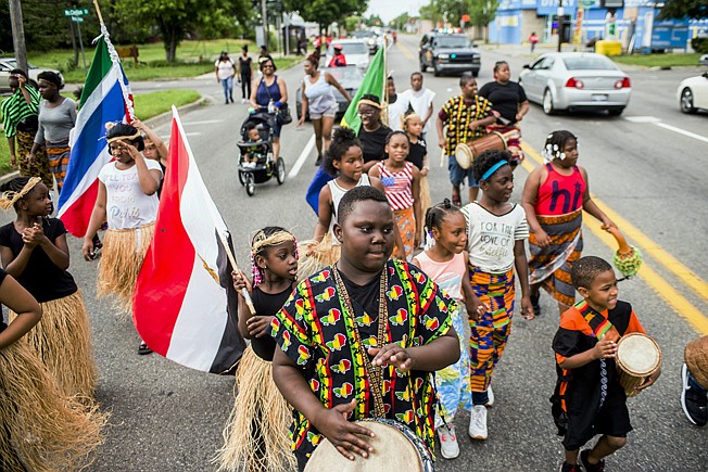 Zebiyan Fields, 11, at center, drums June 19, 2018, alongside more than 20 children at the front of the Juneteenth parade in Flint, Mich.