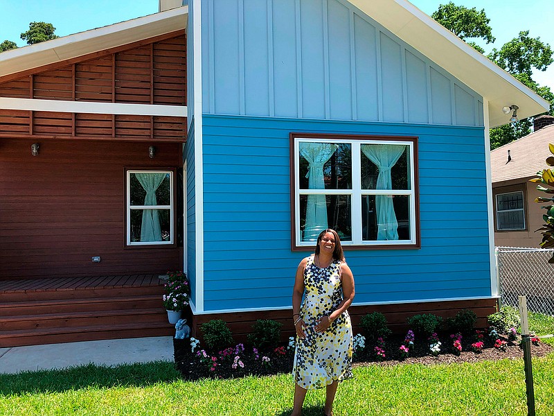 Houston resident Scenacia Jones stands Wednesday in front of her new home, part of an innovative program that builds houses after natural disasters and lets families live in one part of the structure while the rest is completed. The housing program known as Rapido, Spanish for fast, this week debuted its first such home built in Houston.